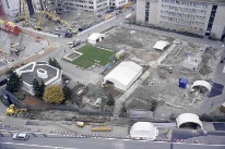 Das Grabungsgelände von Bau 210 aus gesehen, links die Hüningerstrasse. Die Gräber konzentrieren sich vor allem in der linken unteren Ecke, die mit Zelten überdacht ist.